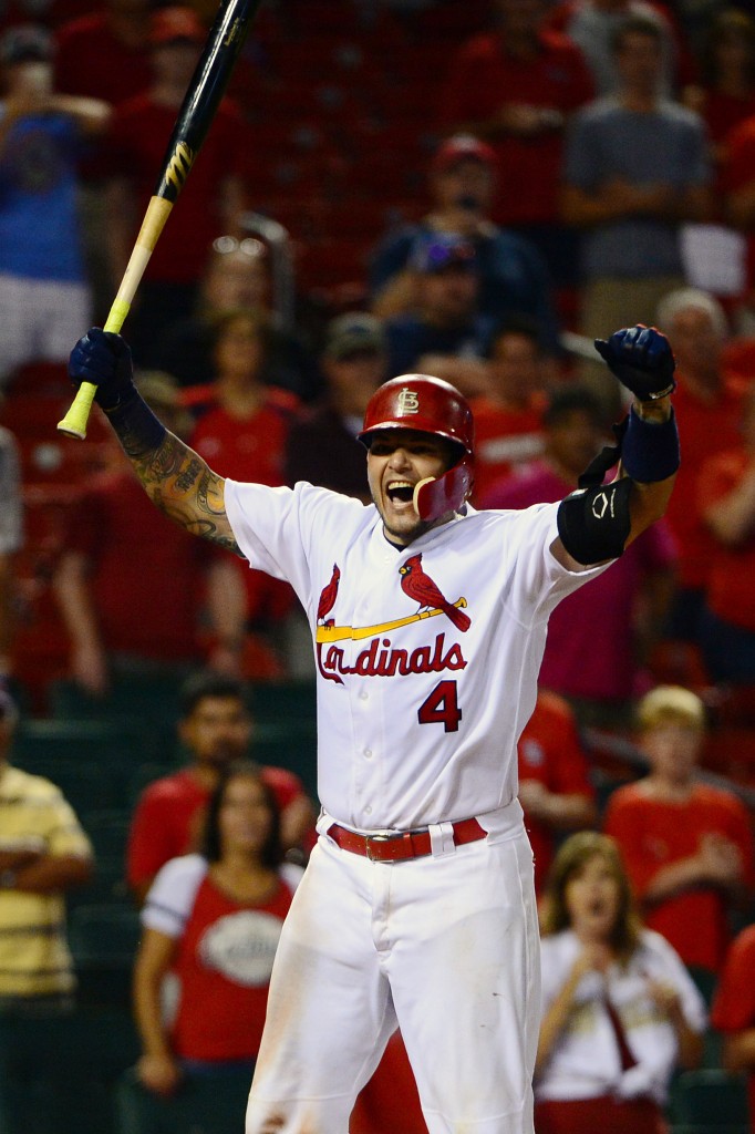 Yadier Molina hands raised in celebration, clenching bat