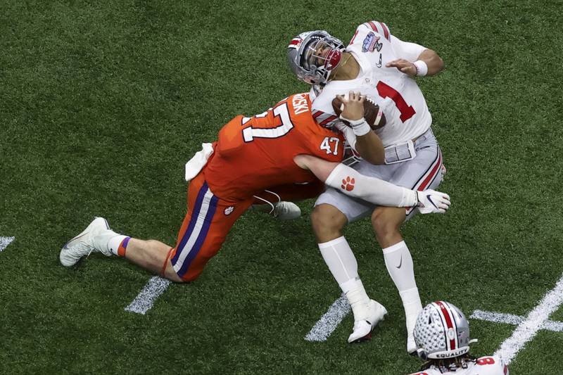 Ohio State quarterback Justin Fields gets hit by Clemson linebacker James Skalski during the first half of the Sugar Bowl NCAA college football game Friday, Jan. 1, 2021, in New Orleans. Skalski was ejected from the game for targeting. (AP Photo/Butch Dill)