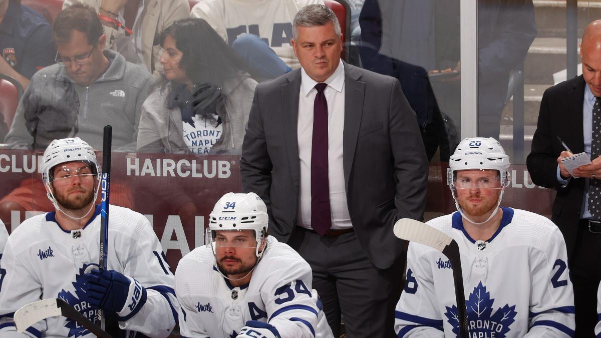 Toronto Maple Leafs head coach Sheldon Keefe stands behind, from left to right, Calle Jarnkrok, Auston Matthews, and Sam Lafferty.