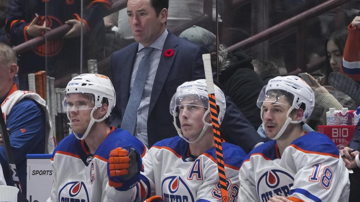 Jay Woodcroft standing behind the bench during an Edmonton Oilers road game in Vancouver.