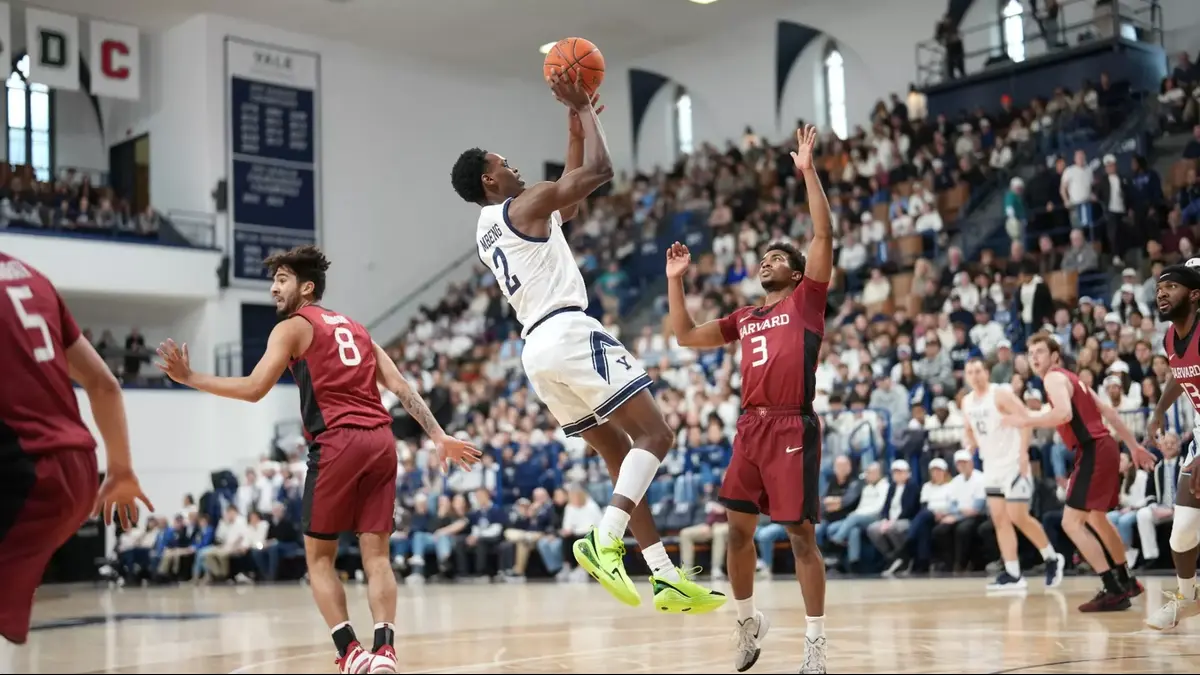 Yale's Bez Mbeng fades away for a shot against Harvard's Xavier Nesbitt in the Bulldogs' 85-54 win over the Crimson on Saturday.